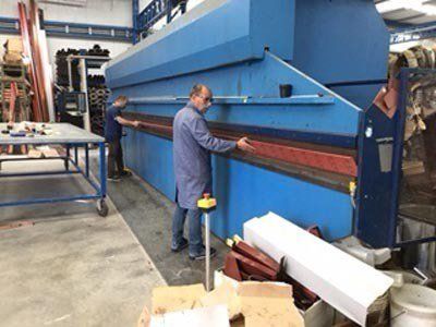 operaio in officina sistema una macchina per lavorazioni serramenti