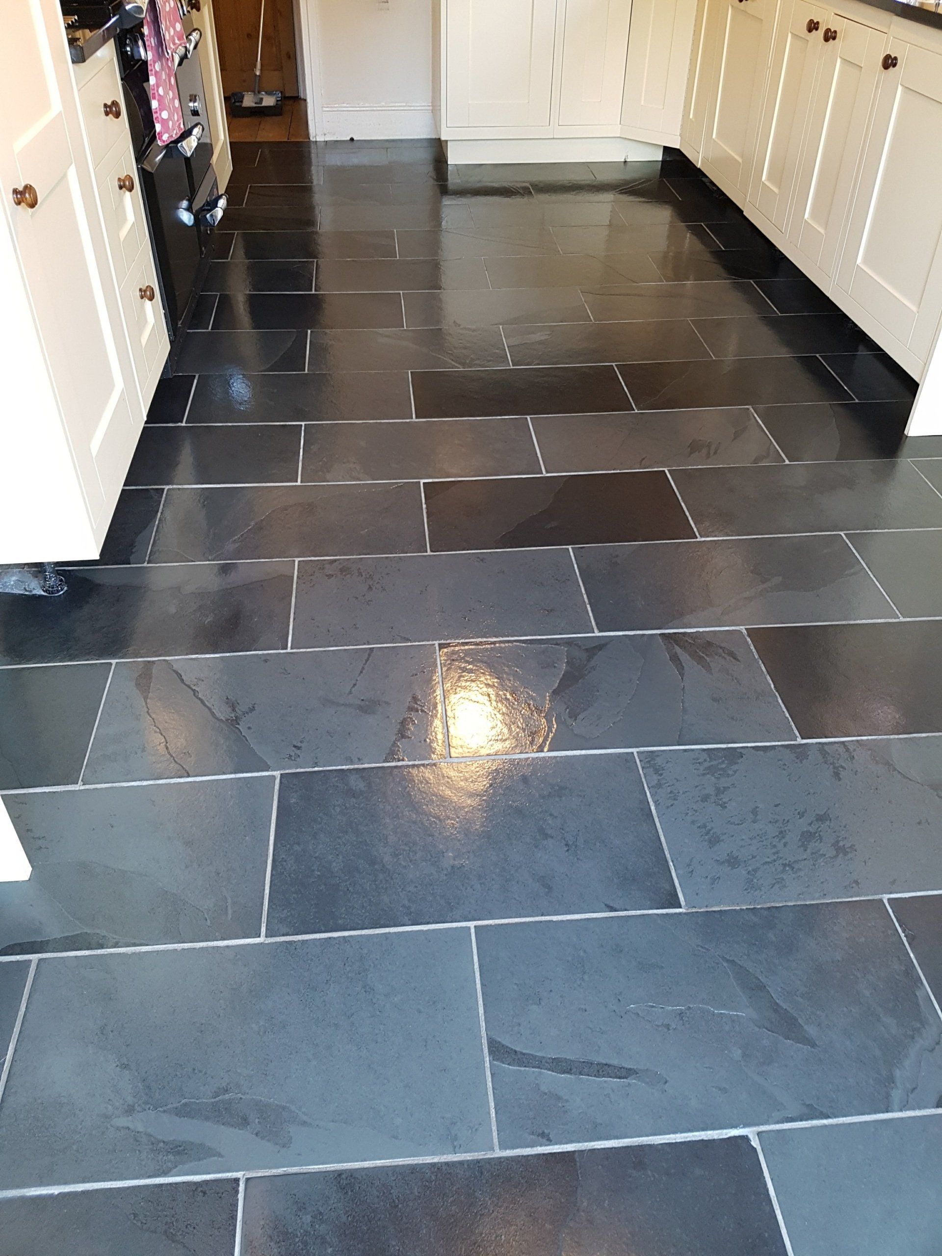 A kitchen with black tile floors and white cabinets