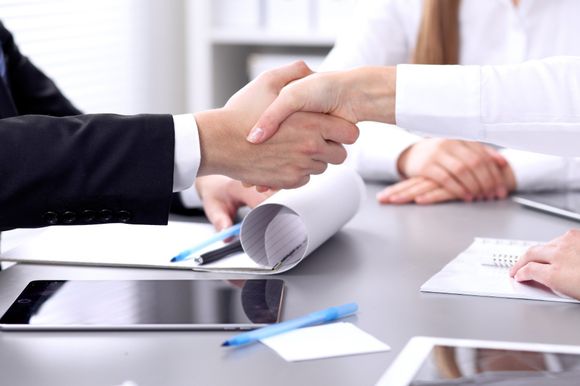 Stretta di mano tra cliente e avvocato durante seduta di divorzio