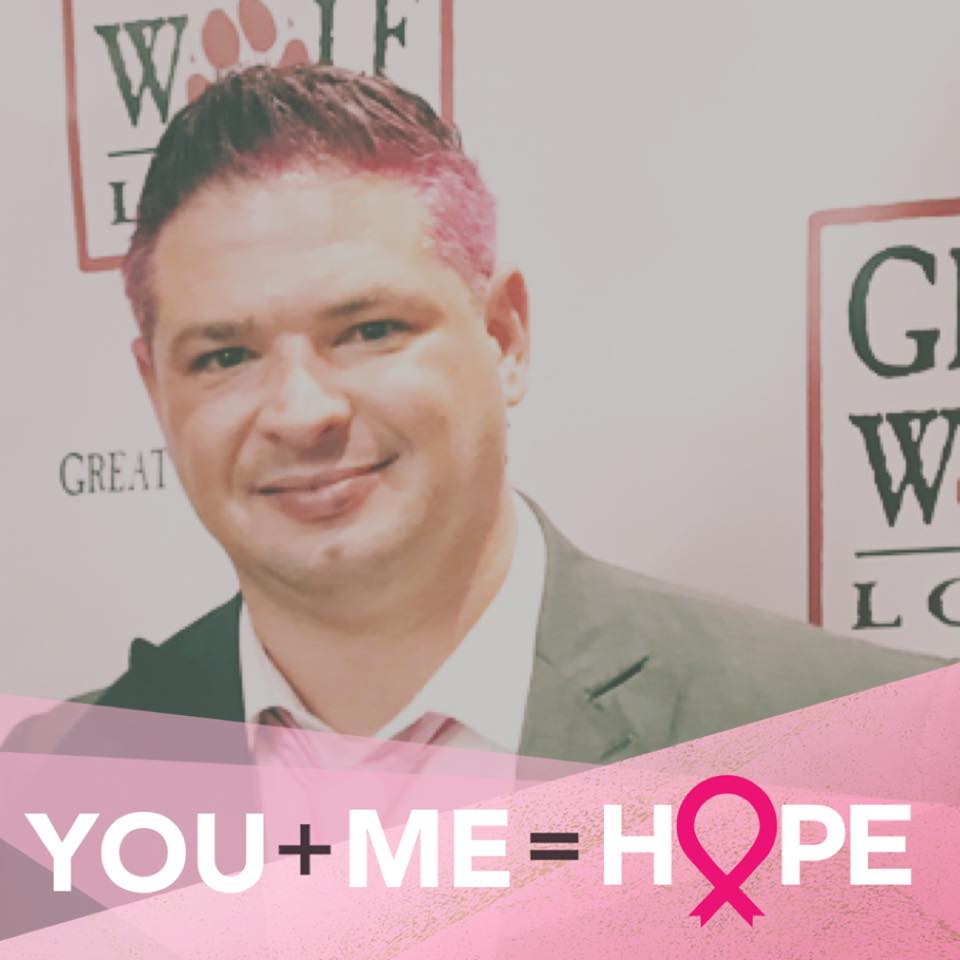 a man with pink hair stands in front of a wolf logo
