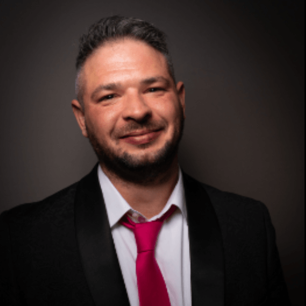 A man in a suit and tie is smiling for the camera