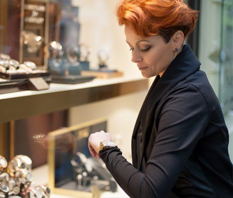Specialty Watches — Woman Looking in a Shop Window with Watches in Madison, WI Specialty Watches — Woman Looking in a Shop Window with Watches in Madison, WI