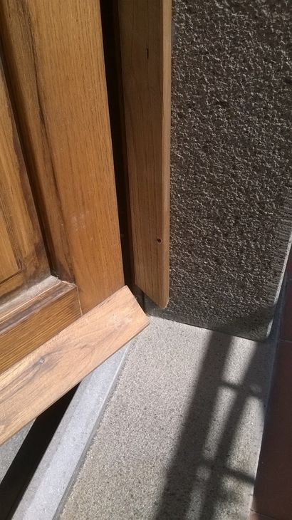 l'esterno di una casa beige con infissi bianchi