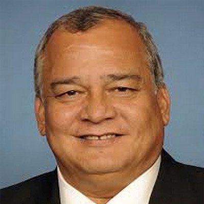A man in a suit and tie is smiling for the camera.