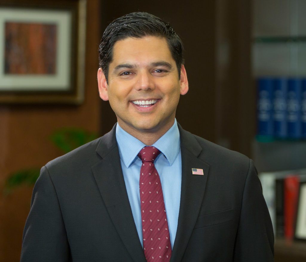 A man in a suit and tie is smiling for the camera