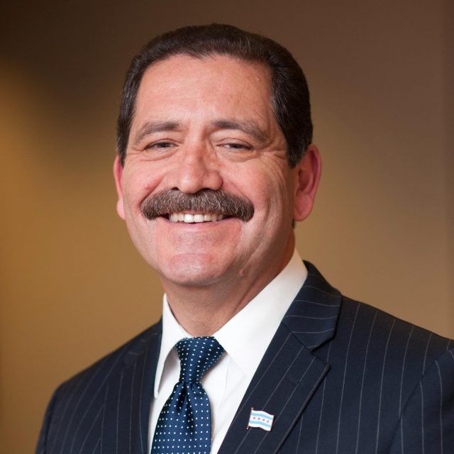 A man with a mustache is wearing a suit and tie