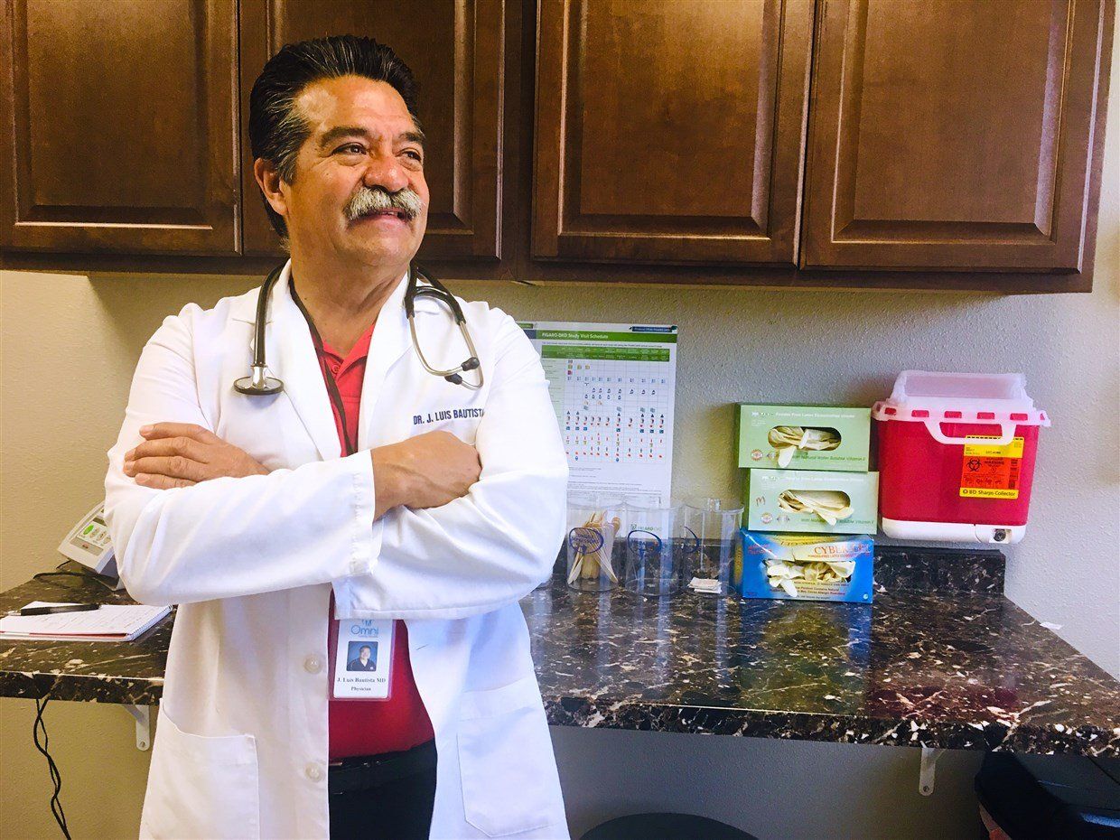 A man in a lab coat with a stethoscope around his neck