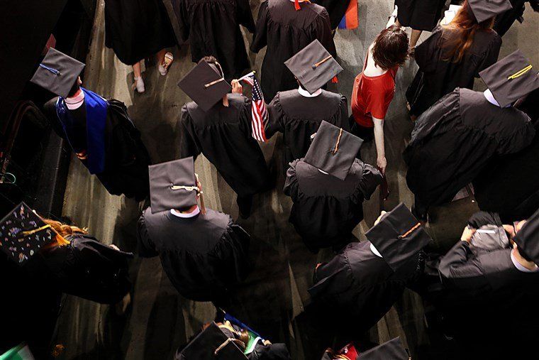 A group of graduates are walking down a hallway.