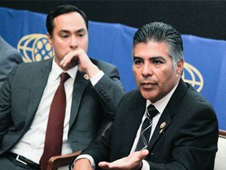 Two men in suits and ties are sitting next to each other