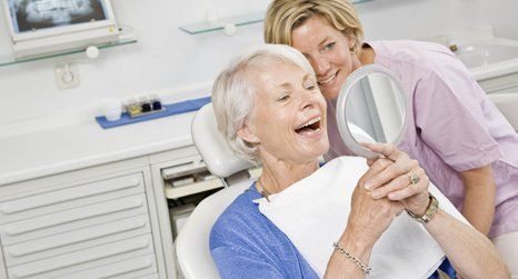 A lady checking her teeth in mirror