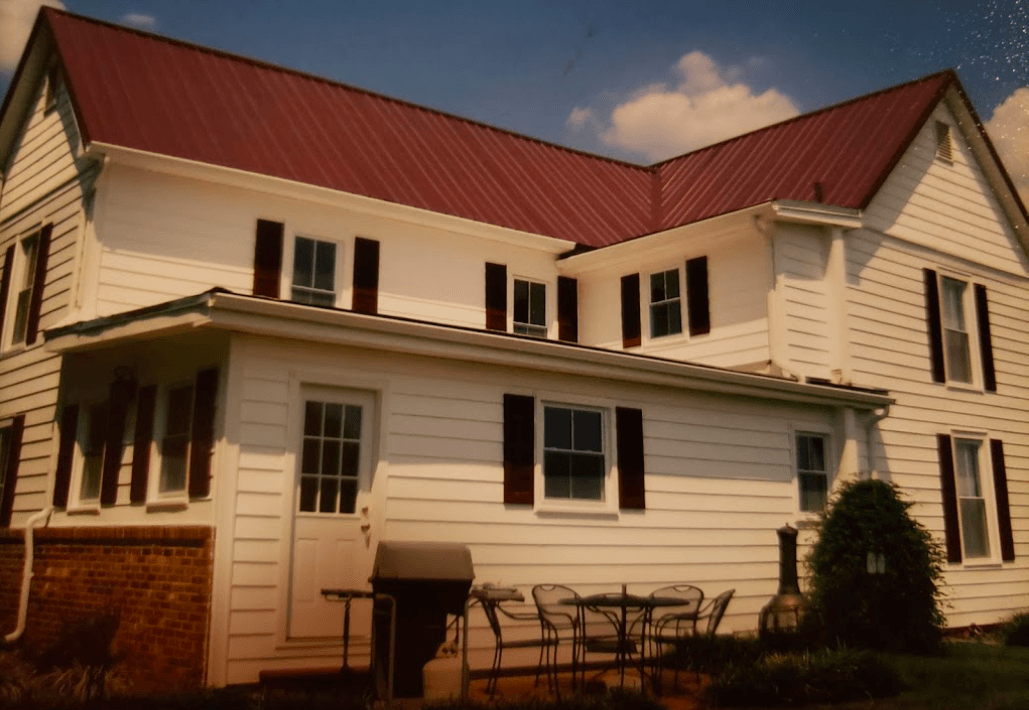 A white house with a red roof and black shutters