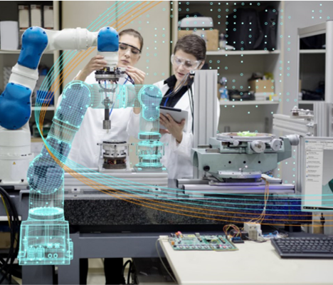 Duas pessoas estão trabalhando em um braço robótico em um laboratório.