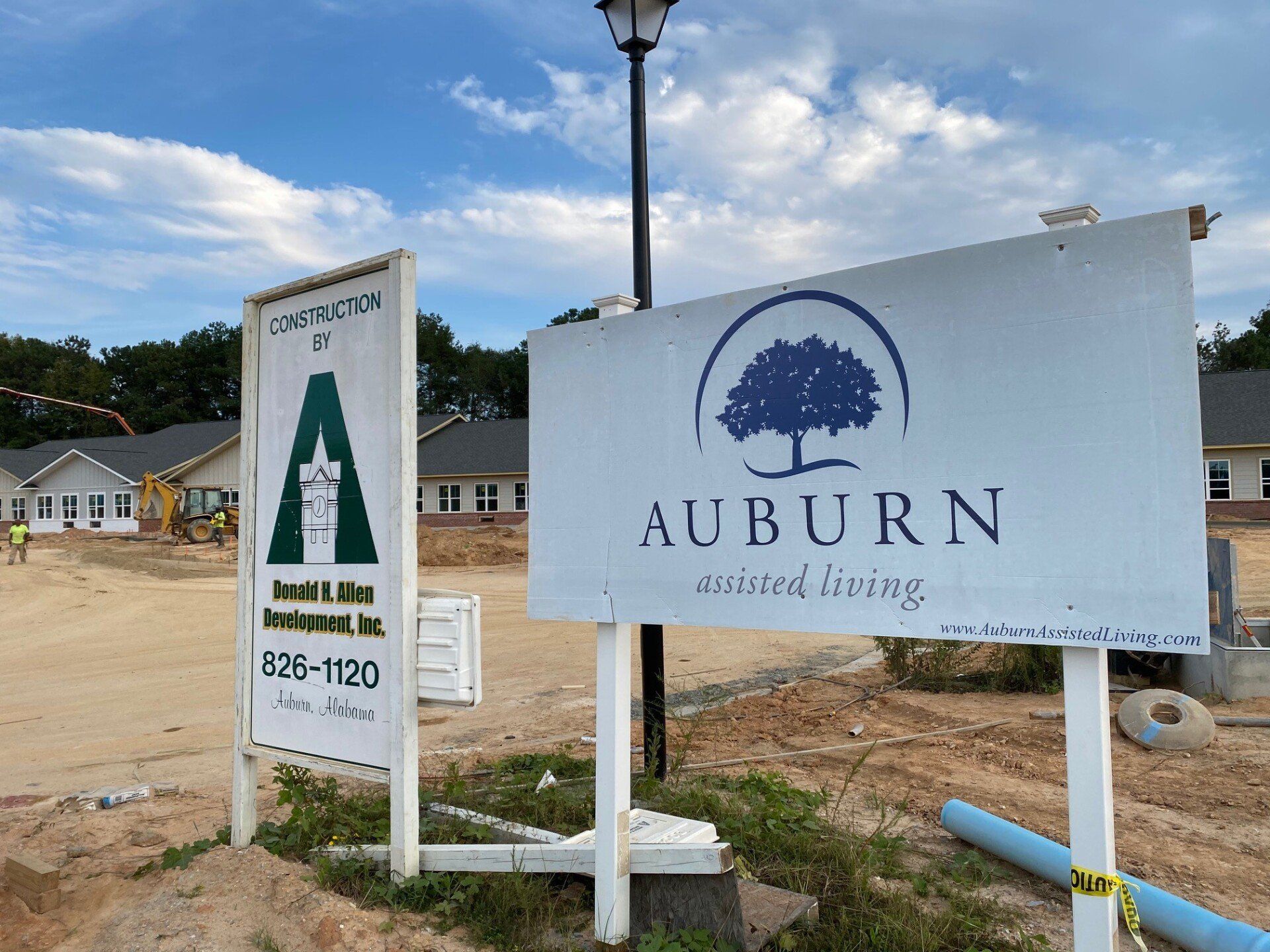 A sign for auburn assured living is in front of a construction site