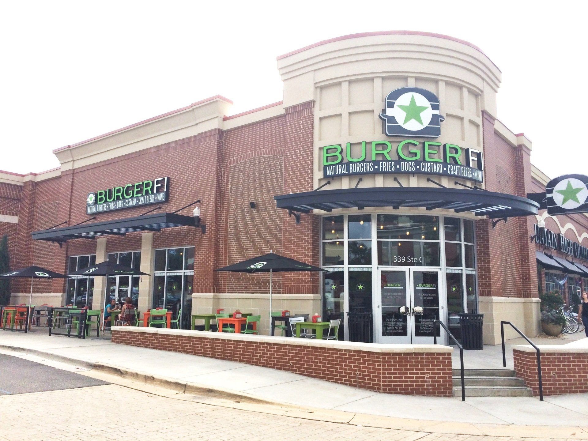 A brick building with a green sign that says burger