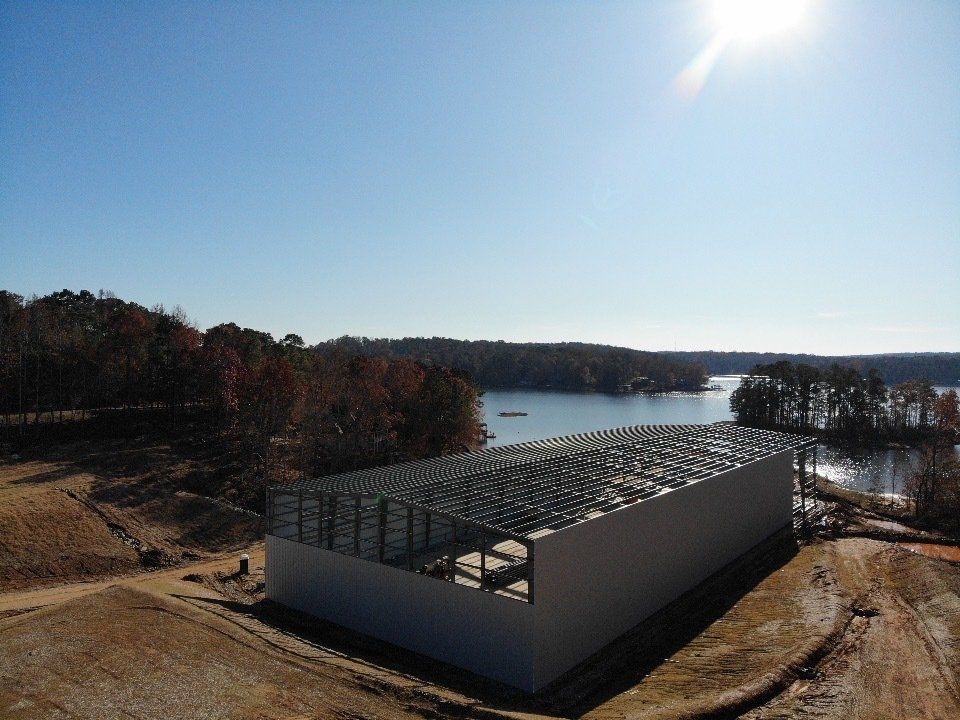 An aerial view of a building under construction next to a lake.