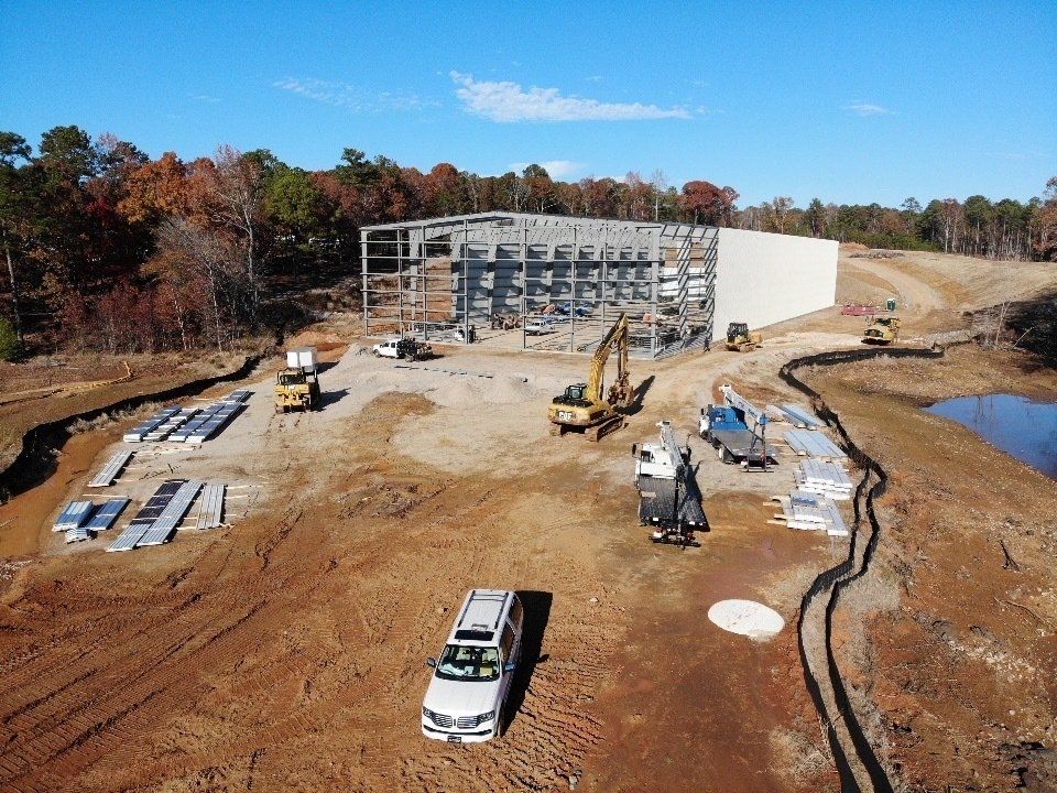 An aerial view of a construction site with a truck parked in the dirt.