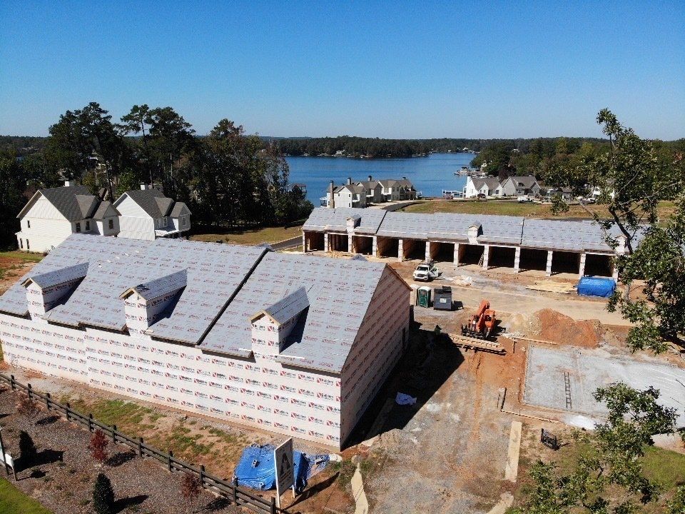 An aerial view of a building under construction with a lake in the background