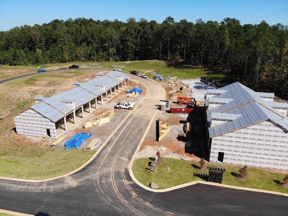 An aerial view of a building under construction surrounded by trees