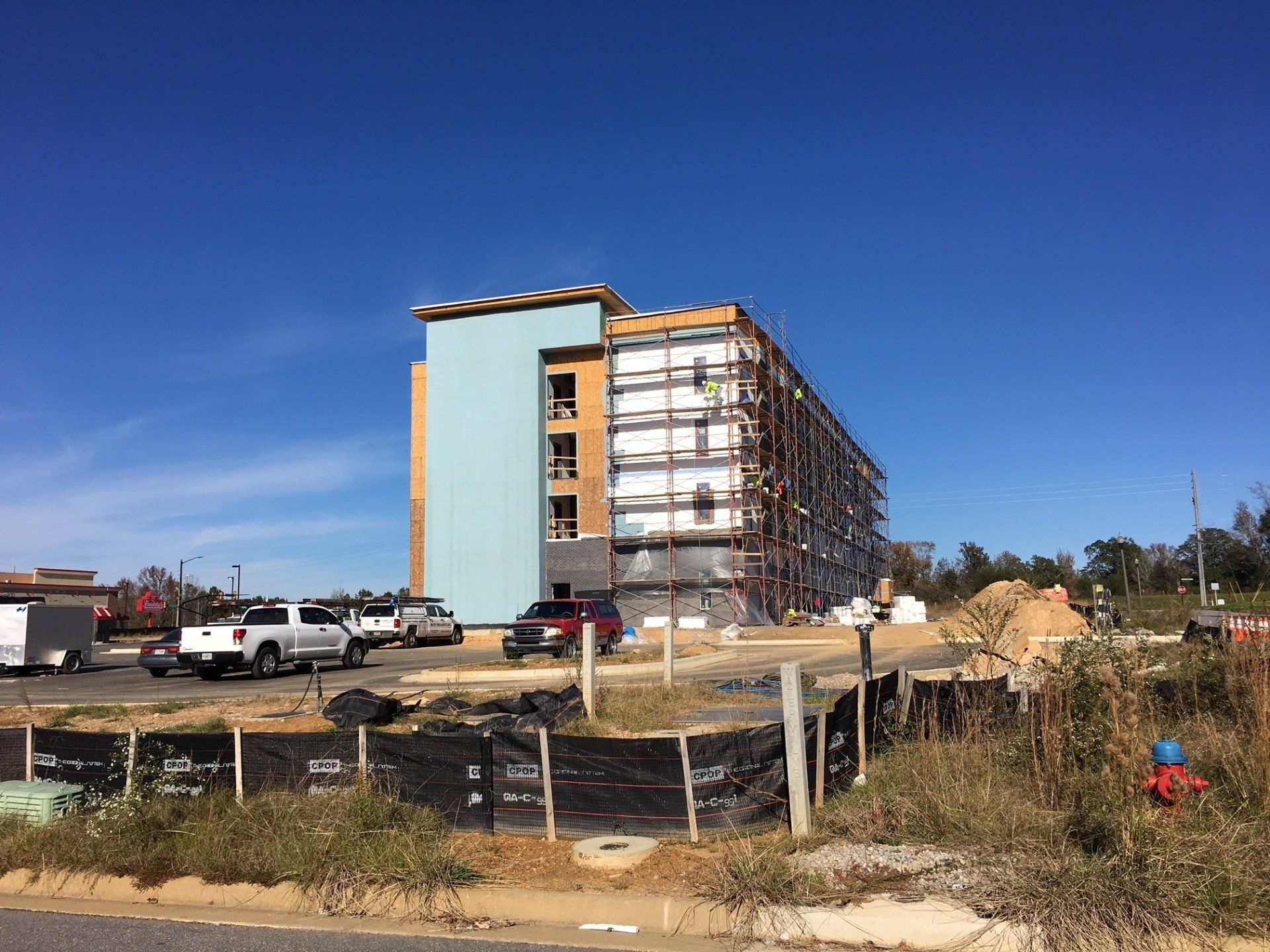 A large building is being built on the side of the road.