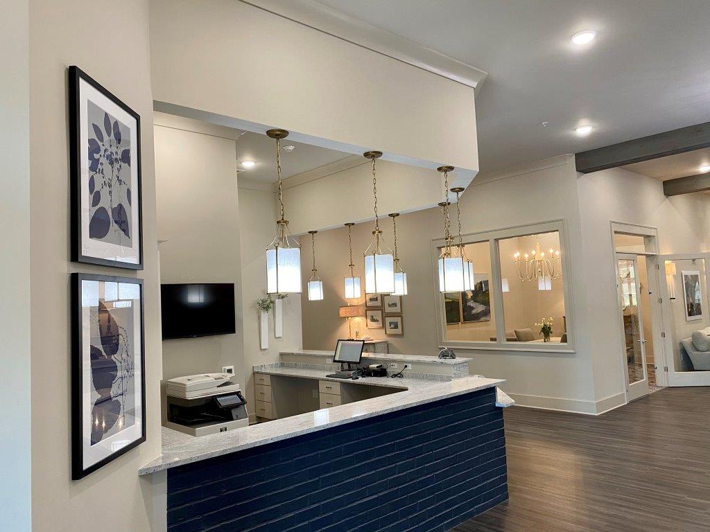A lobby with a blue counter and a tv on the wall.