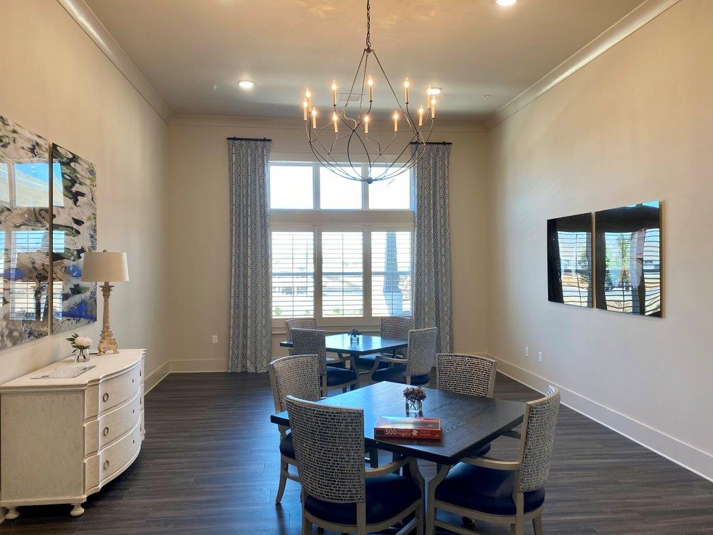 A large dining room with a table and chairs and a chandelier.