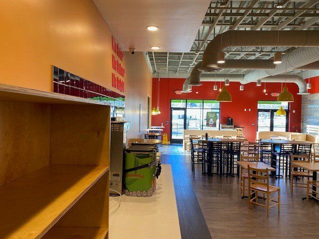 The inside of a restaurant with tables and chairs