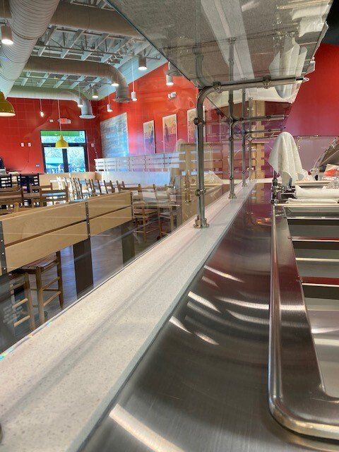 A long stainless steel counter in a restaurant