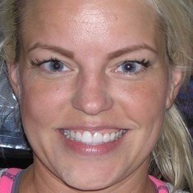 A close up of a woman 's face with a smile on her face.