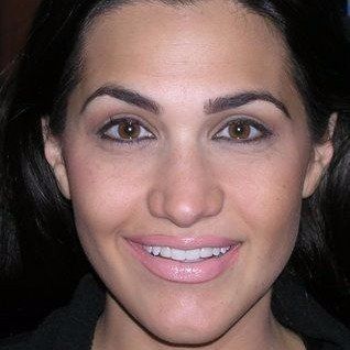 A close up of a woman 's face with a smile on her face.