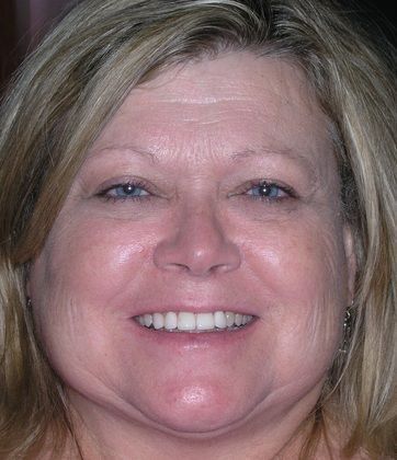 A close up of a woman 's face with a smile on her face.