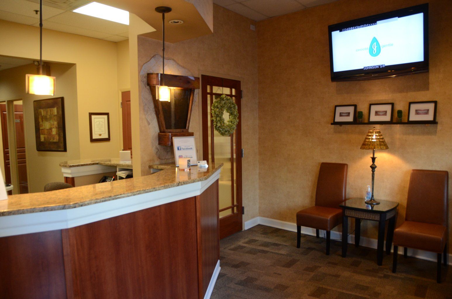 A waiting room with a counter and chairs and a tv on the wall