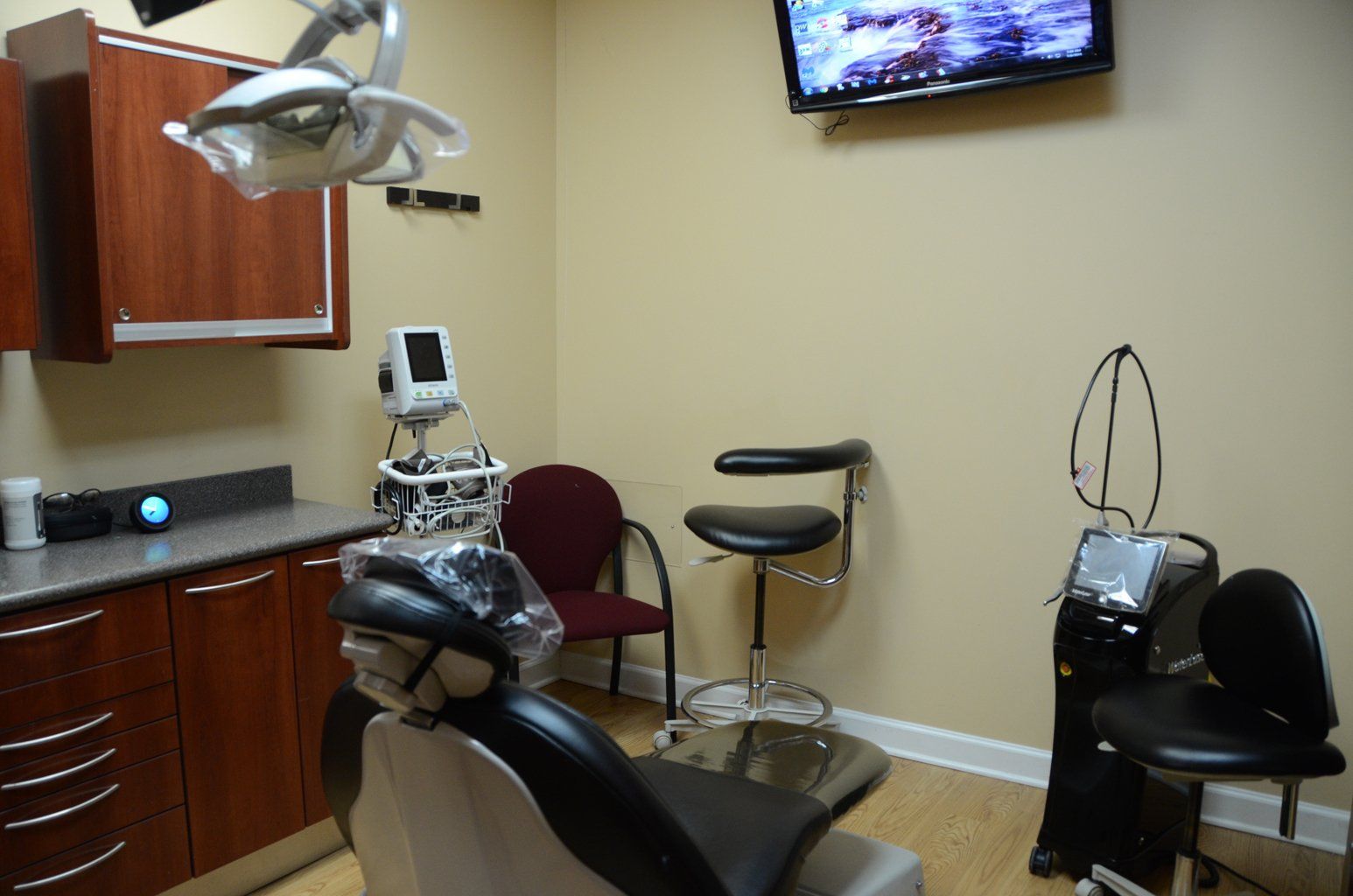 A dental office with a dental chair and a television