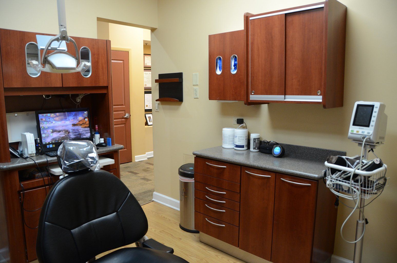 A dental office with a dental chair and a monitor