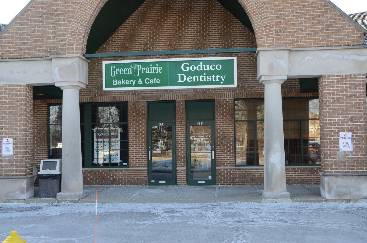 A brick building with a green sign that says goduco dentistry