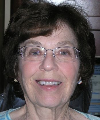 A close up of a woman wearing glasses and smiling