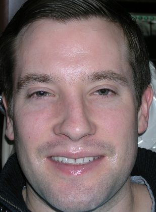 A close up of a man 's face with a smile on his face.