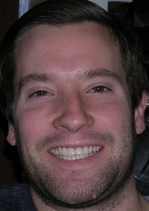 A man with a beard is smiling for the camera.
