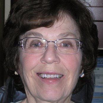 A close up of a woman wearing glasses and smiling.