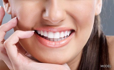 A close up of a woman 's mouth with her hand on her chin.