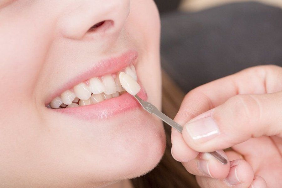 A woman is getting her teeth examined by a dentist.