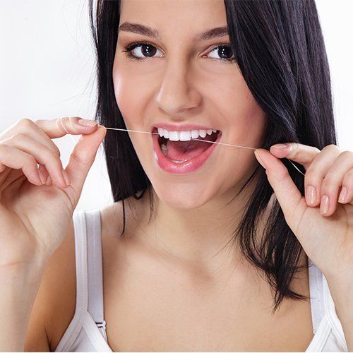 woman flossing teeth