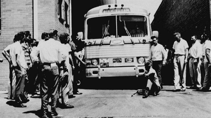 a black and white photo of a group of people standing in front of a bus that says pg 6-1