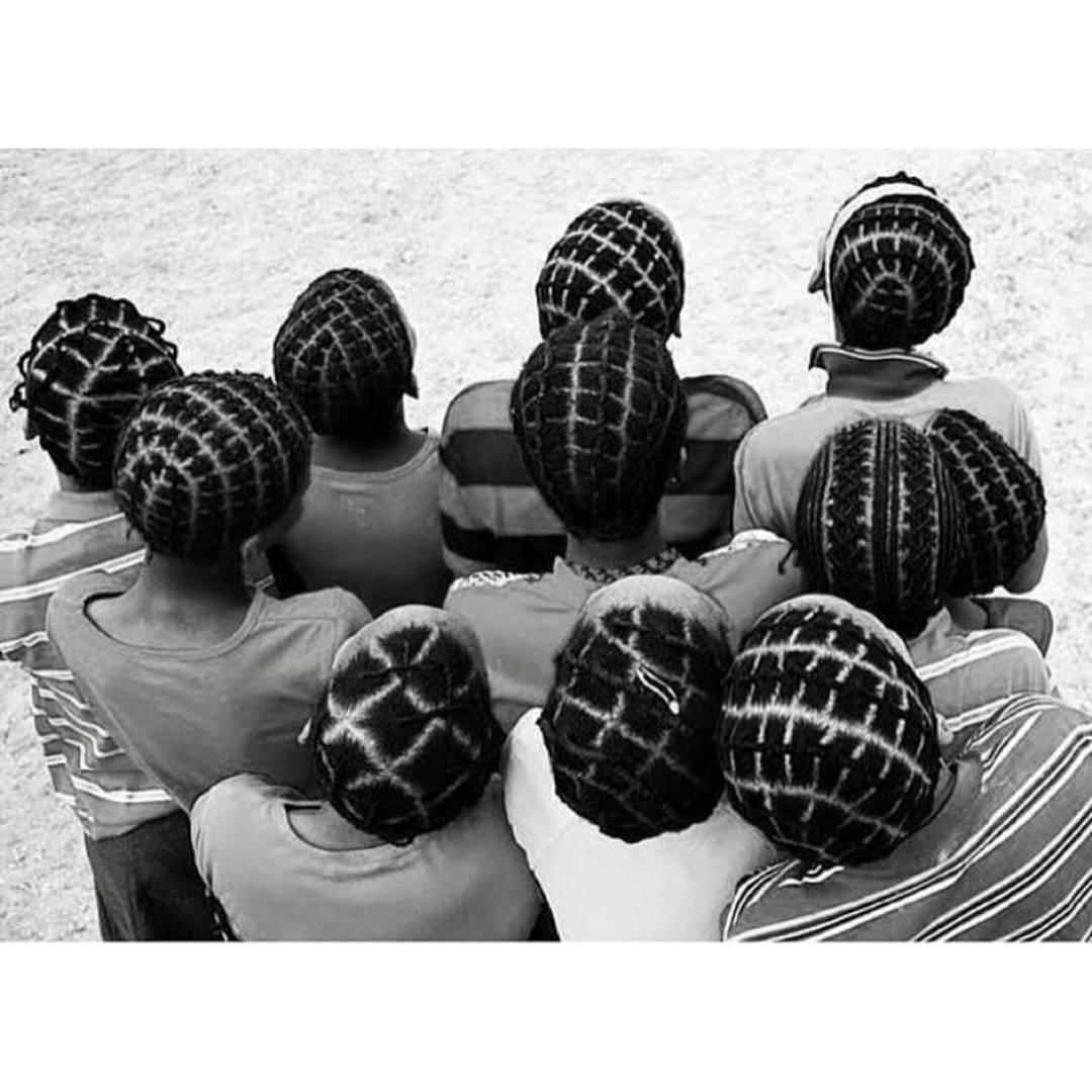 a black and white photo of a group of people sitting in a circle .
