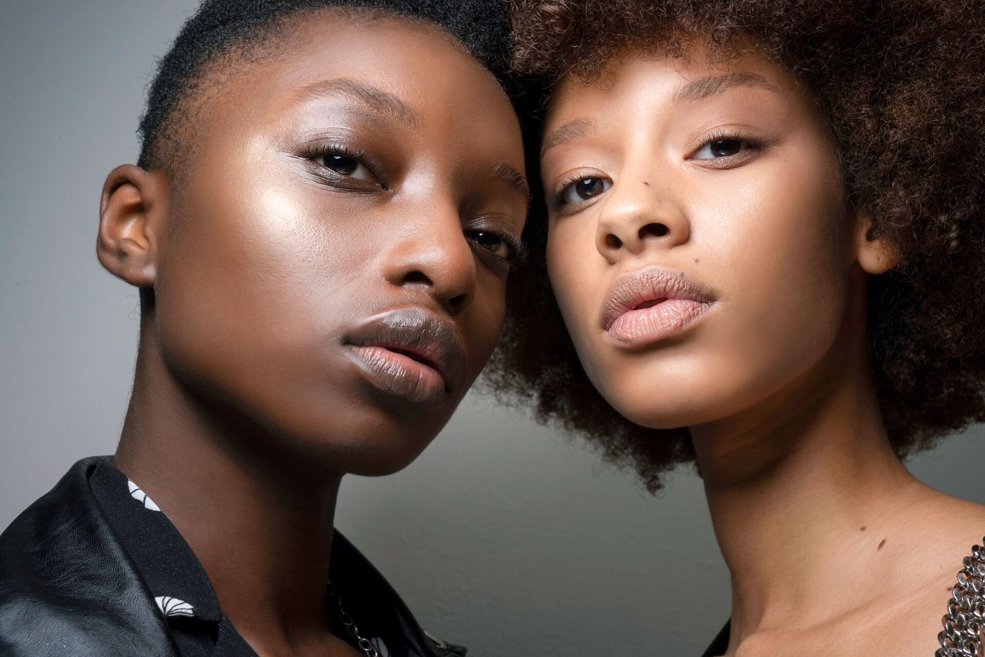 two women are standing next to each other and looking at the camera .