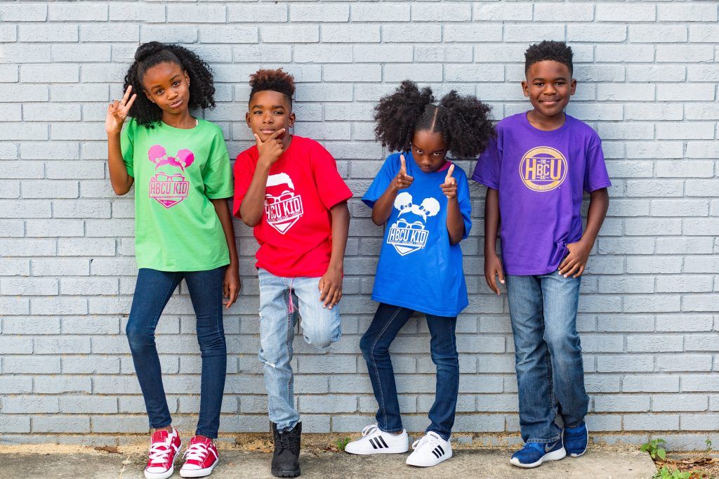a group of children standing in front of a brick wall