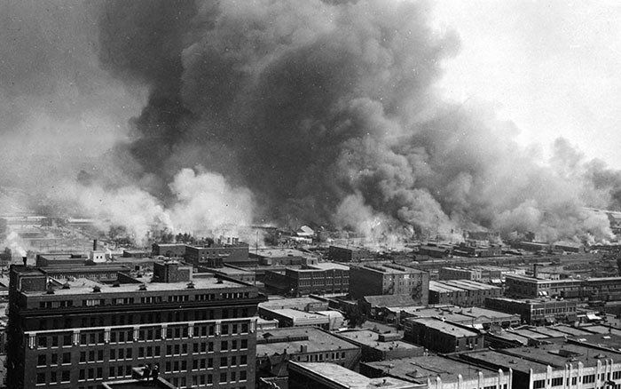 a black and white photo of a city with smoke coming out of it