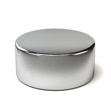 A round metal object is sitting on a white surface.