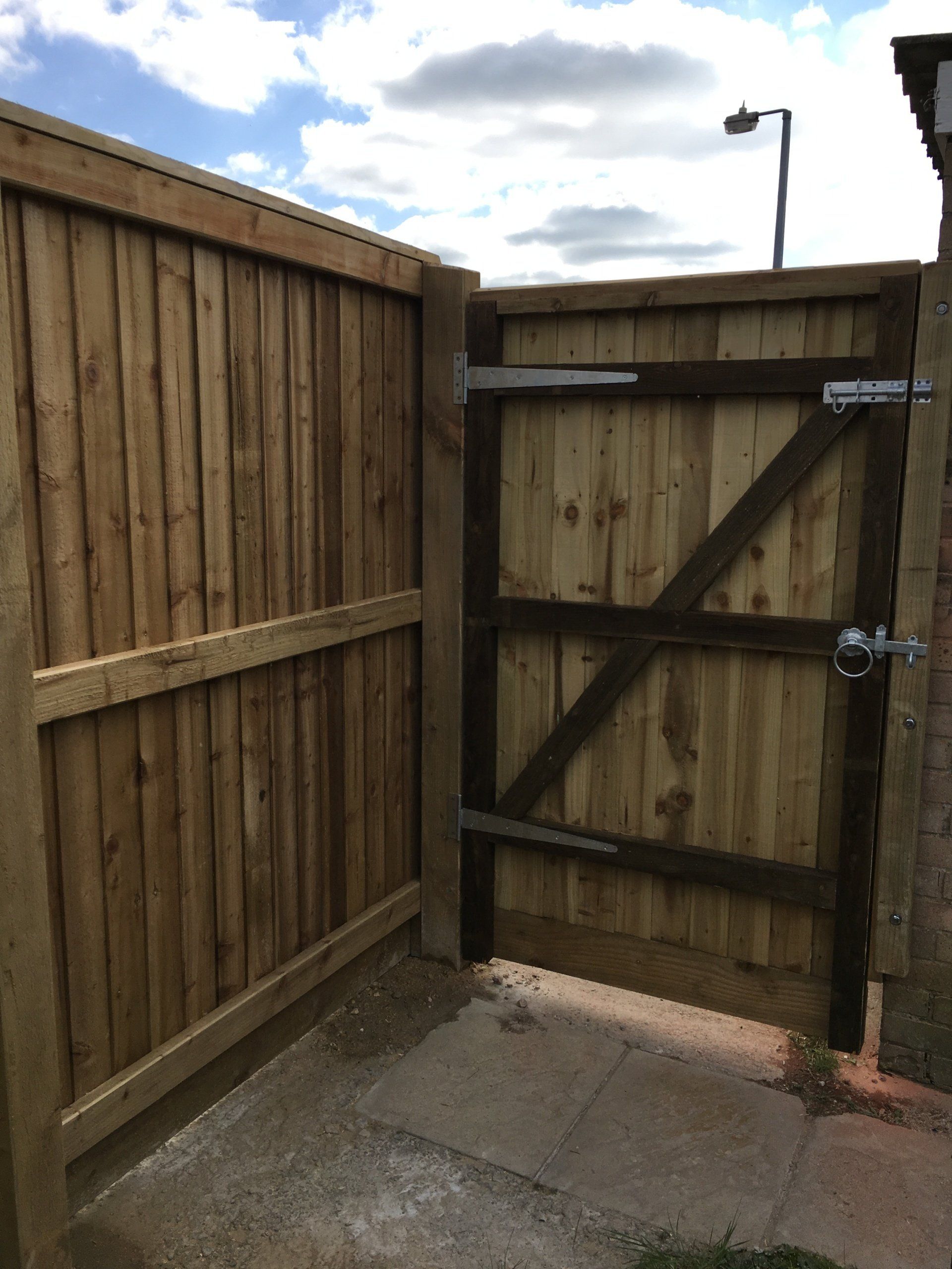 A wooden fence with a gate in the middle of it.