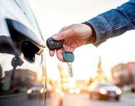 Locksmith Service — Woman with Car Key in Morganville, NJ