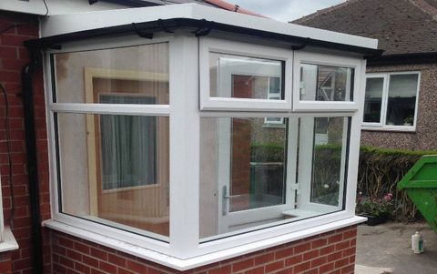 a small conservatory with brick walls and glass doors